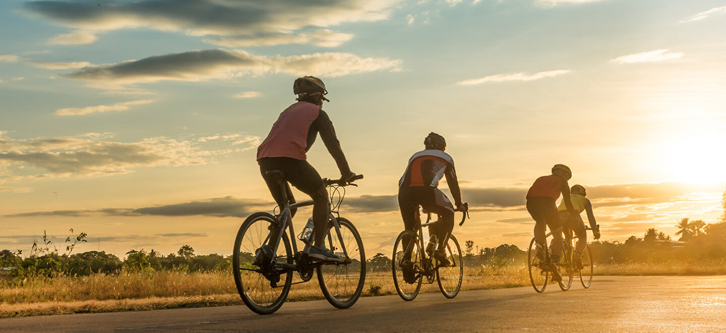 three bicycles riding during a sunset
