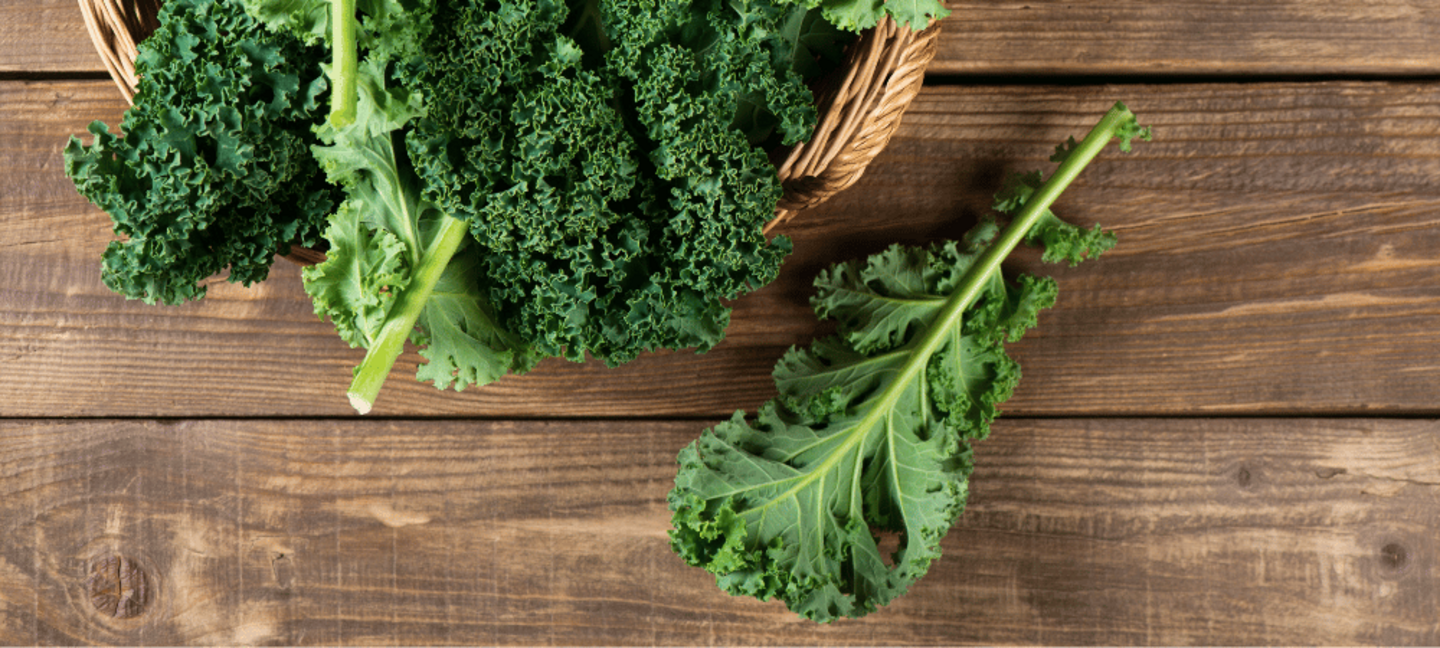 raw kale leaves on a wooden table