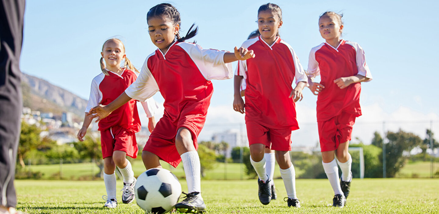 kids playing soccer with red uniforms