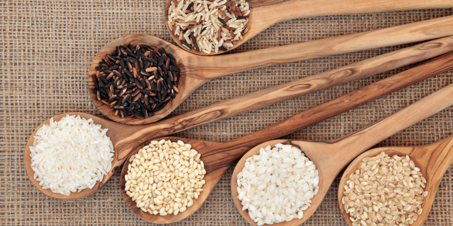 Rice varieties in olive wood spoons.