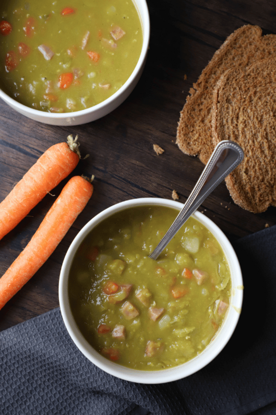Split pea soup in a bowl with whole wheat bread on the side