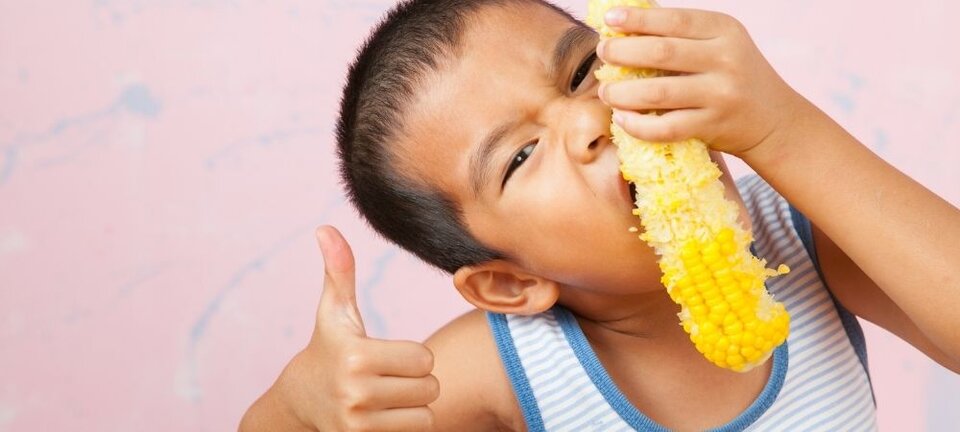 child eating corn
