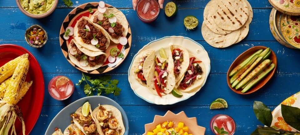 table of food with tortillas, corn, salsa