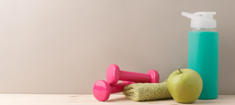 small dumbbells with apple, water bottle, and towel