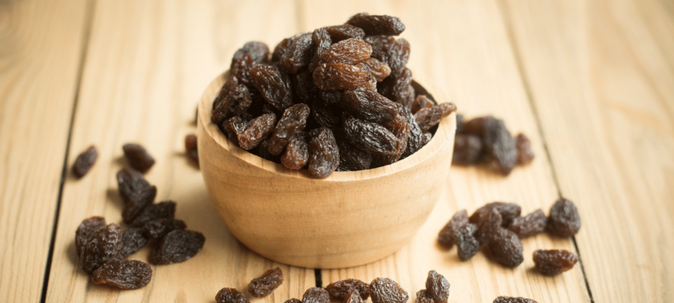 raisins in a wooden bowl on a table