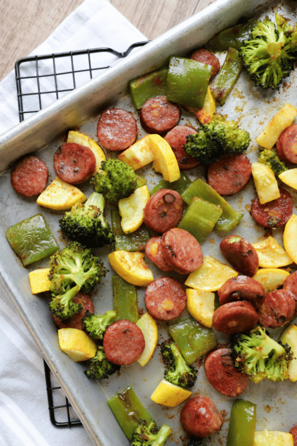 Sausage, bell peppers, summer squash and broccoli on a sheet pan