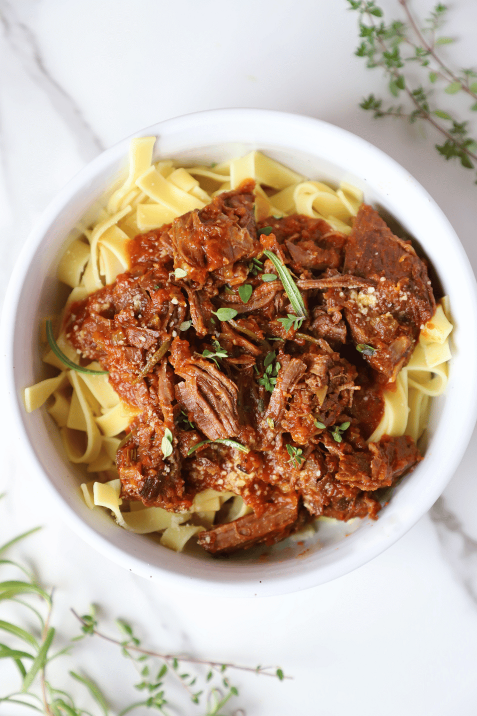 A bowl of beef ragu over noodles