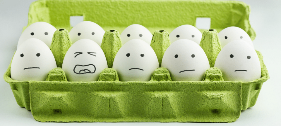 variety of stressed faces drawn on eggs