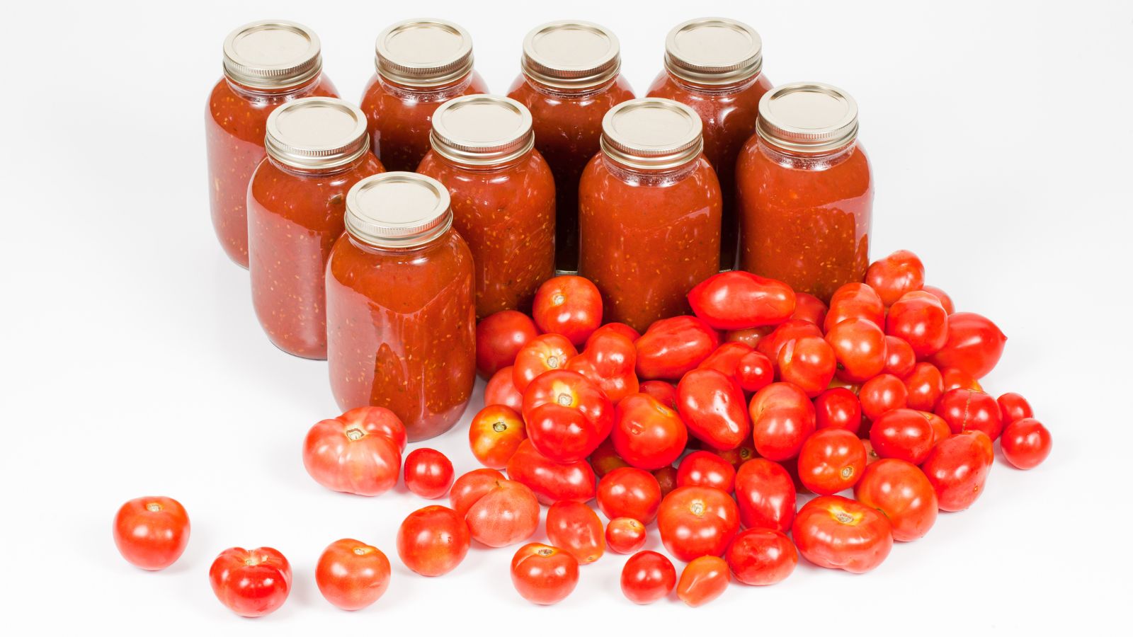 canned tomatoes in jars and fresh tomatoes