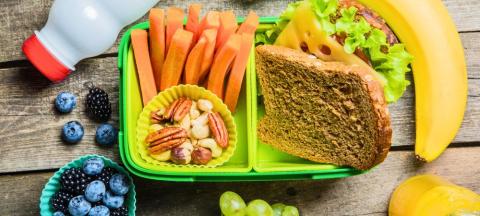 packed lunch with sandwich, banana, carrots, nuts, blueberries