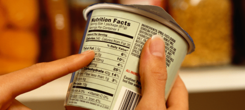 person reading a nutrition facts label on a food item