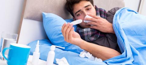 sick person with thermometer and tissues