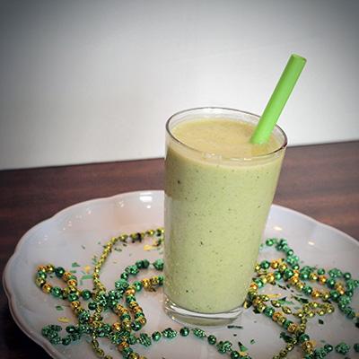 Clover power smoothie on a plate with St. Patrick's Day decorations