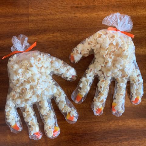 plastic gloves filled with popcorn and candy corn