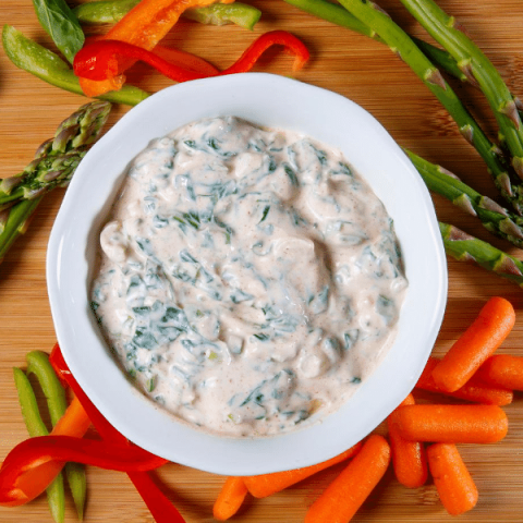 low-fat spinach dip with fresh vegetables on a cutting board