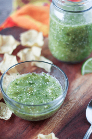Tomatillo salsa in a cup and mason jar with tortilla chips