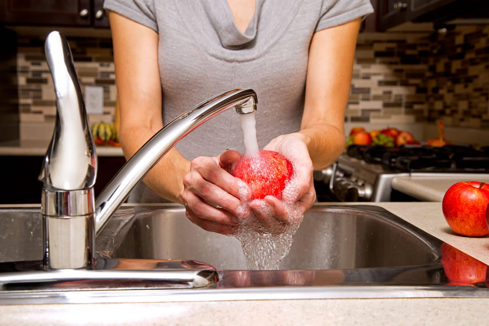 Washing an apple in the sink